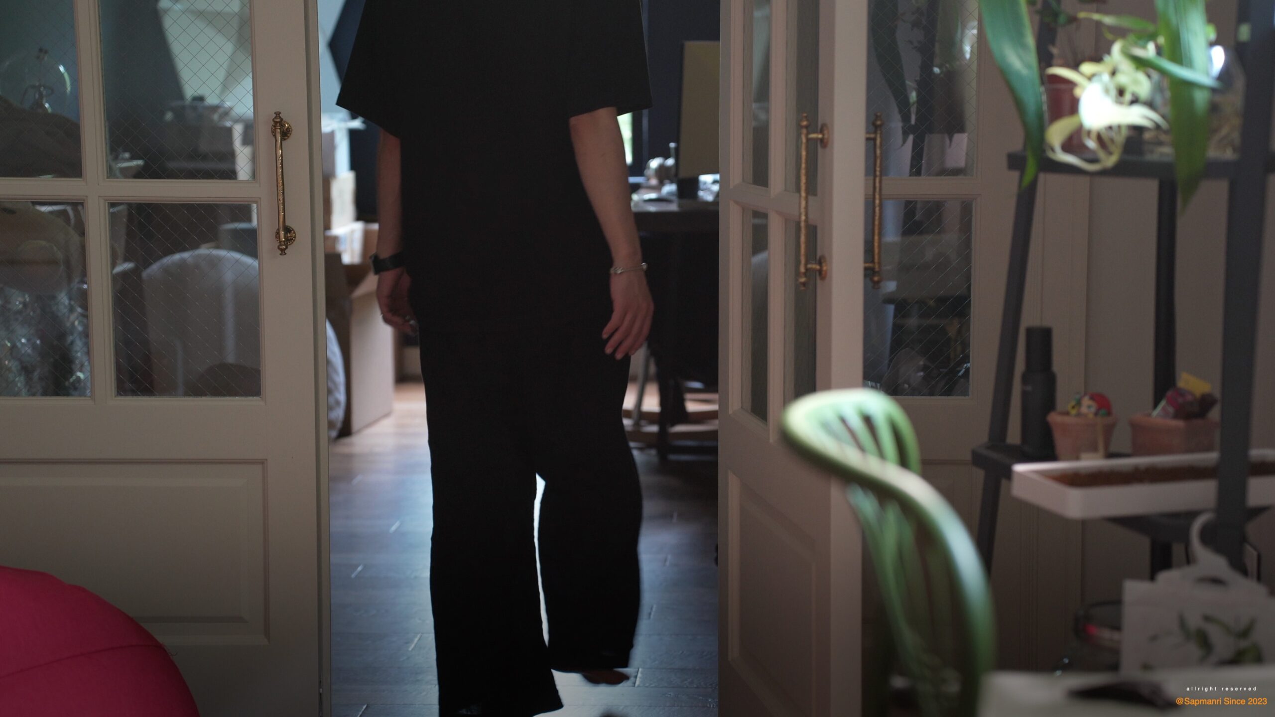 A person walking through an interior doorway at the end of a work session.
