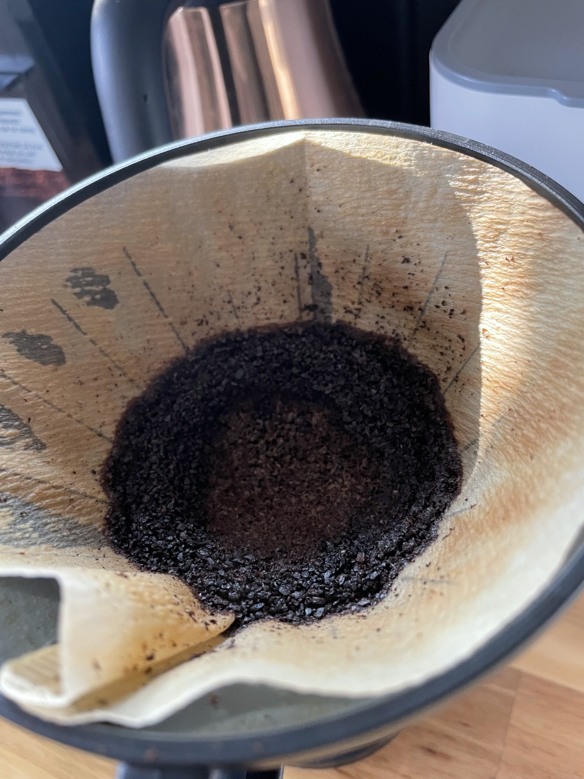 Spent coffee grounds resting in a paper filter after brewing.