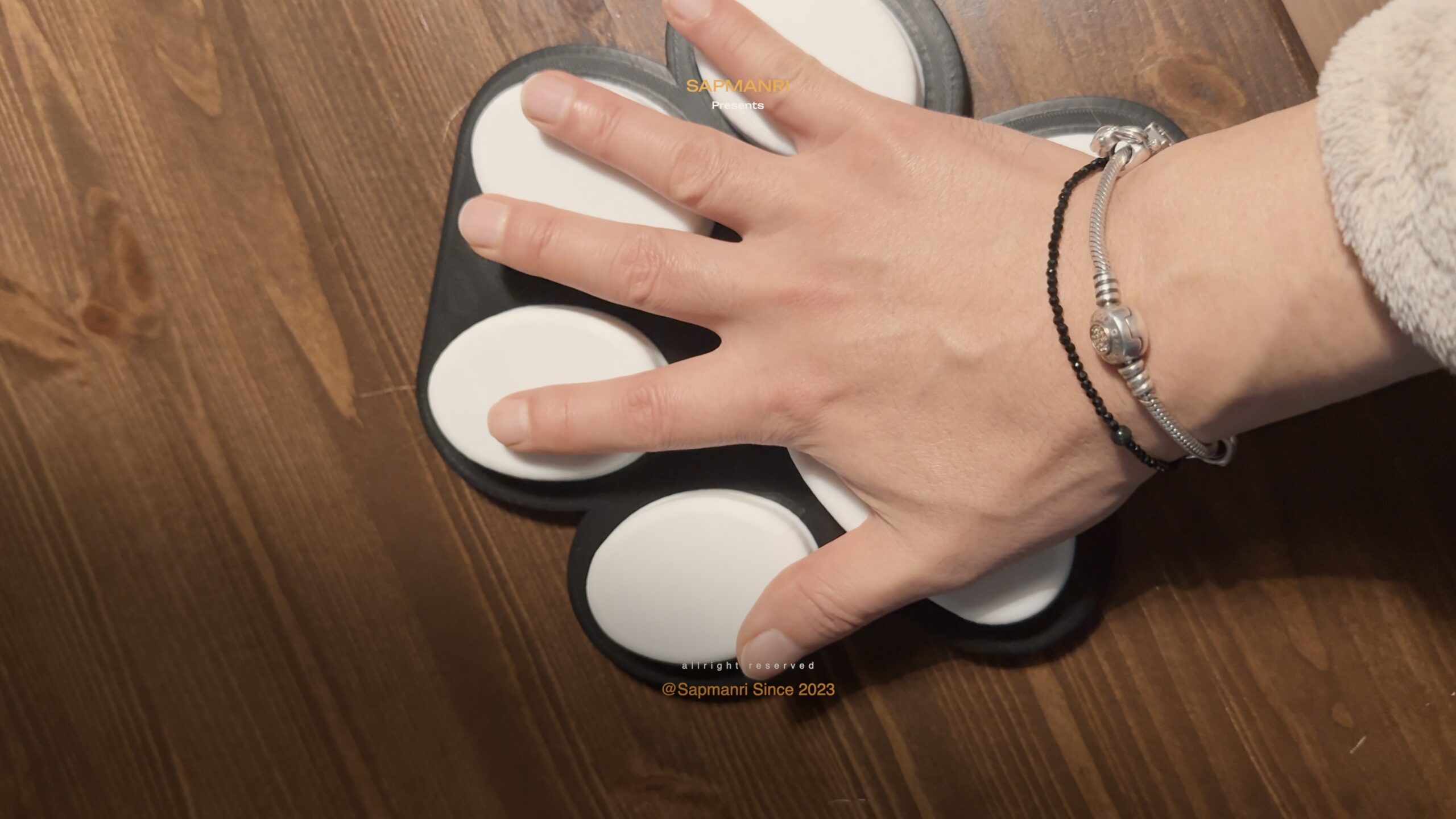 A hand holding one oversized pale cat-paw sole with four toe pads and a large central pad.
