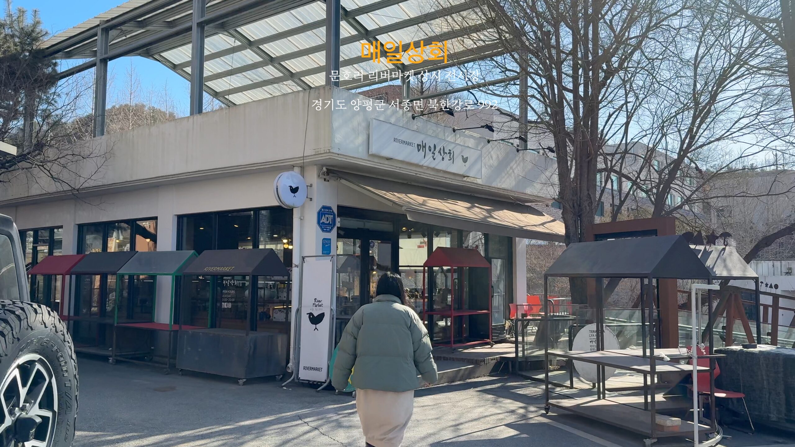 A person approaching the Munhori River Market Maeil Sanghoe building in winter.