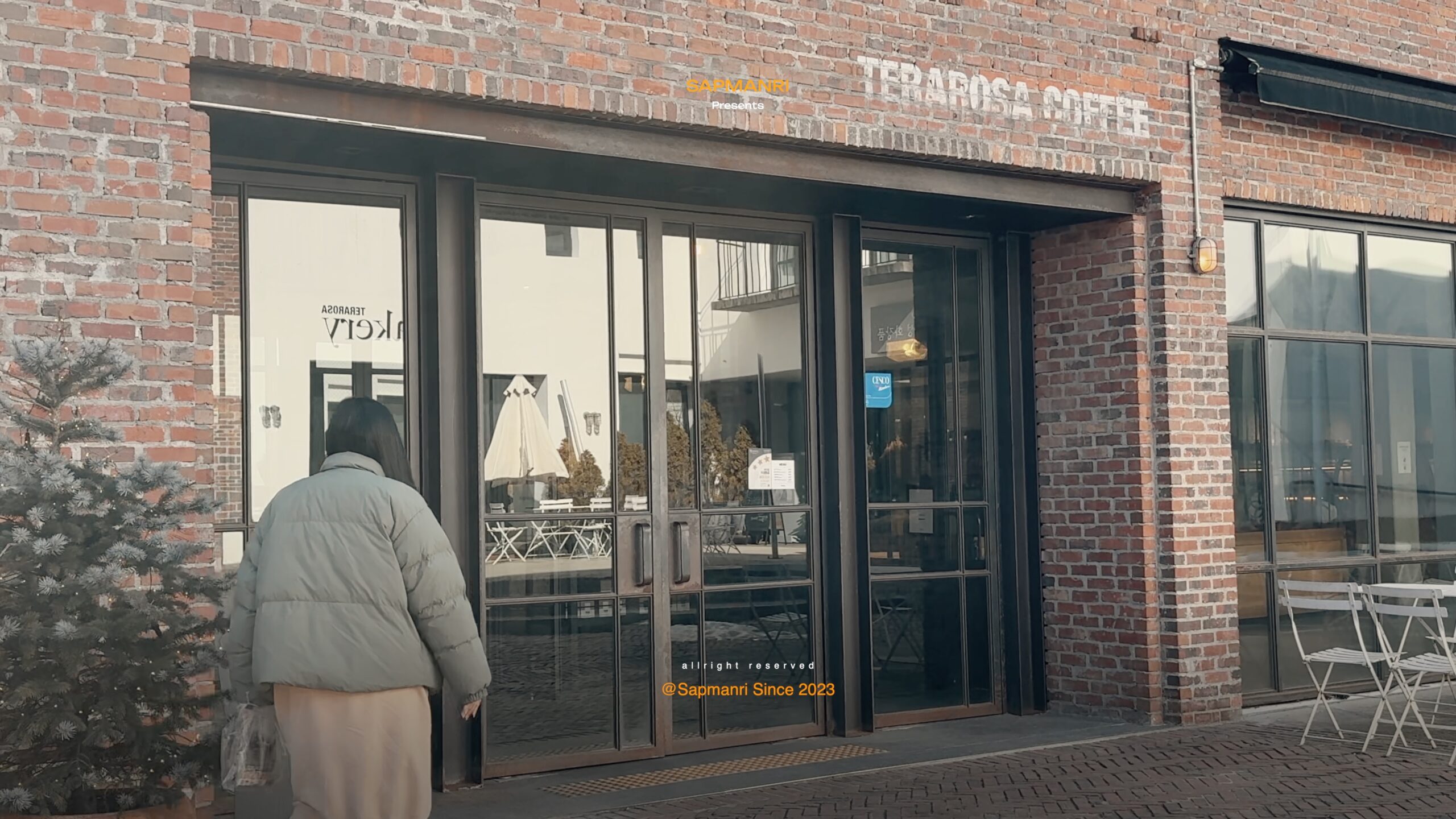 A person approaching the brick entrance of Terarosa Coffee in Seojong.